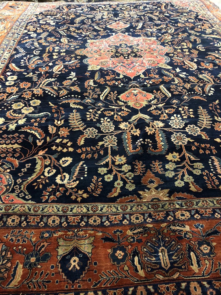 Navy rug with colorful floral motifs and an ornate border