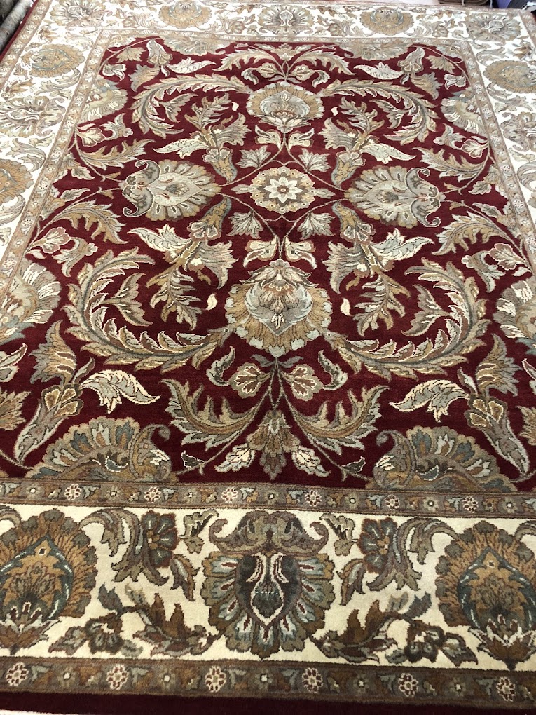 Red floral rug with an ivory and green decorative border