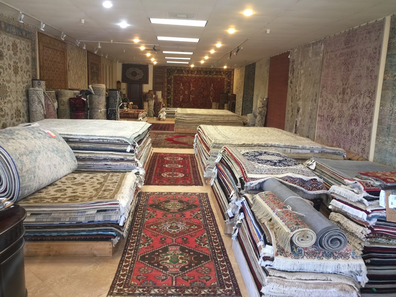 An aisle lined with rugs and wall displays at Diamond Rug Gallery